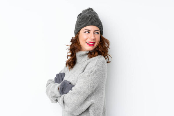Young Russian woman with winter hat over isolated white background laughing