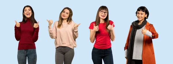 Conjunto Mulheres Sobre Fundo Azul Isolado Dando Gesto Polegar Para — Fotografia de Stock