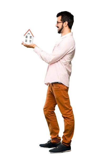 Handsome man with beard holding a little house — Stock Photo, Image