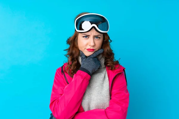 Lyžařka Snowboardovými Brýlemi Přes Izolovanou Modrou Stěnu Přemýšlí Nápadu — Stock fotografie