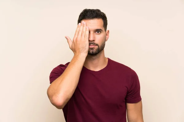 Bonito Homem Sobre Fundo Isolado Cobrindo Olho Mão — Fotografia de Stock