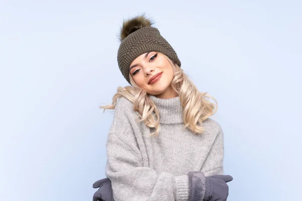 Kışlık Şapkalı Genç Kız Mavi Arka Planda Gülüyor — Stok fotoğraf