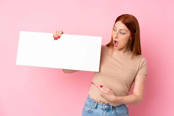 Joven Pelirroja Sobre Fondo Rosa Aislado Sosteniendo Cartel Blanco Vacío — Foto de Stock