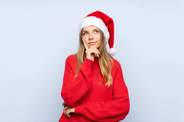 Chica Con Sombrero Navidad Sobre Fondo Azul Aislado Pensando Una — Foto de Stock