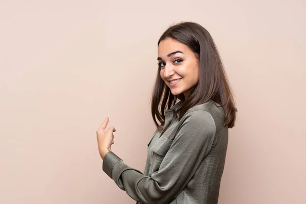 stock image Young girl over isolated background pointing back