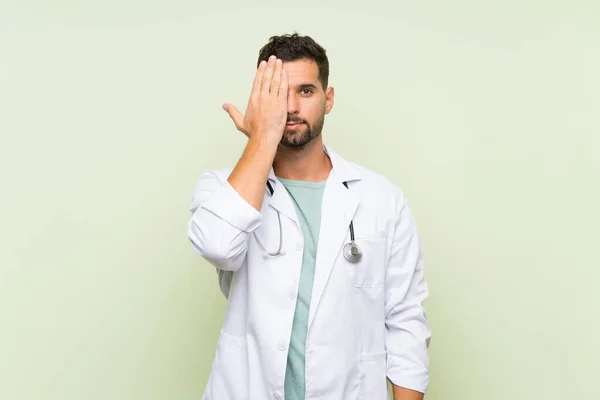 Jovem Médico Homem Sobre Isolado Parede Verde Cobrindo Olho Mão — Fotografia de Stock