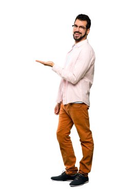 Tam uzunlukta atış görünümlü doğru izole beyaz arka plan üzerinde gülümseyen iken bir fikir sunmak sakallı yakışıklı adam