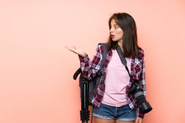 Avuç üzerinde copyspace hayali tutan izole pembe arka plan üzerinde Genç fotoğrafçı kız