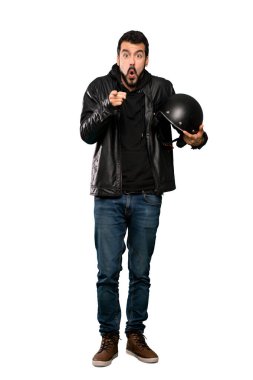 Motosikletli adamın tam boy görüntüsü şaşırdı ve izole edilmiş beyaz arkaplanı işaret etti.