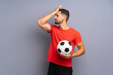 Yakışıklı genç futbolcu, izole edilmiş beyaz duvarın üzerinden bir şey fark etti ve çözüme niyetlendi.