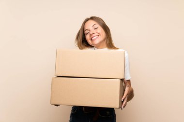 Sarışın bir kadın, izole edilmiş bir arka planda, kutuyu başka bir yere taşımak için tutuyor.
