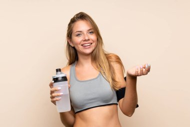 Genç sarışın sporcu kız izole edilmiş arka planda spor su şişesiyle