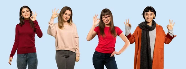 Conjunto Mulheres Sobre Fundo Azul Isolado Mostrando Sinal Com Dedos — Fotografia de Stock