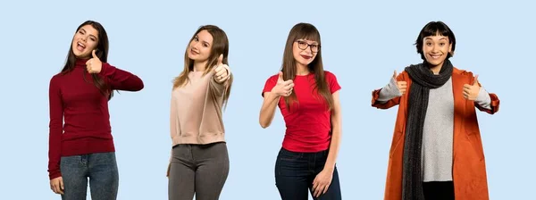 Conjunto Mulheres Sobre Fundo Azul Isolado Com Polegares Para Cima — Fotografia de Stock