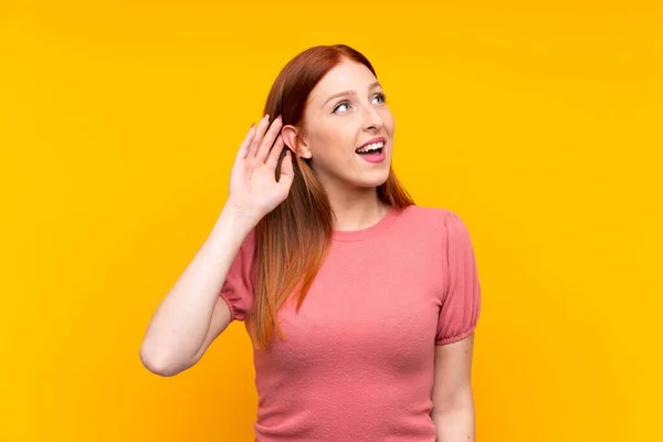 Jeune Rousse Femme Sur Fond Jaune Isolé Écoutant Quelque Chose — Photo