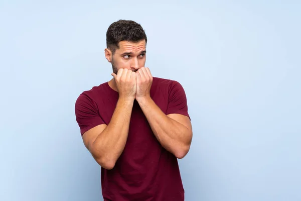 Bonito Homem Sobre Isolado Fundo Azul Nervoso Assustado Colocando Mãos — Fotografia de Stock