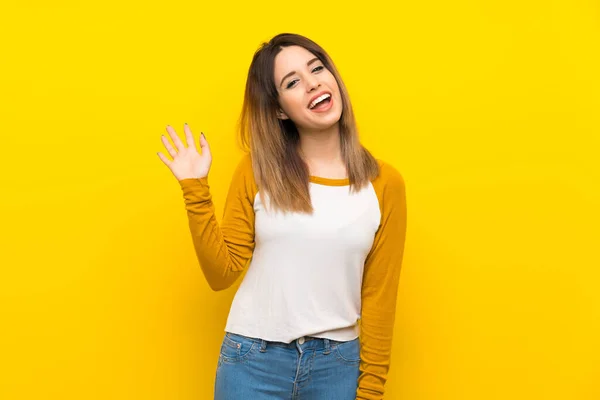 Mulher Bonita Sobre Parede Amarela Isolada Saudando Com Mão Com — Fotografia de Stock