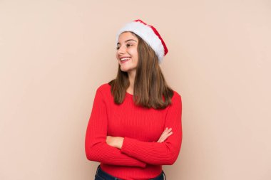 Yılbaşı şapkası takmış genç bir kız, gülüyor.