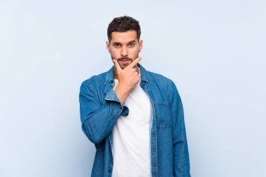 Izole mavi arka plan düşünme üzerinde Yakışıklı adam