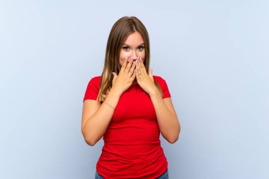 Yüzü sürpriz bir ifadeyle mavi arka planda kalan genç bir kız.