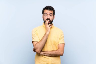 Mavi arka planda sakallı genç adam sağa bakarken şaşırdı ve şok oldu.