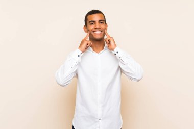 Genç, yakışıklı, esmer, soyutlanmış, mutlu ve hoş bir ifadeyle gülümseyen bir adam.