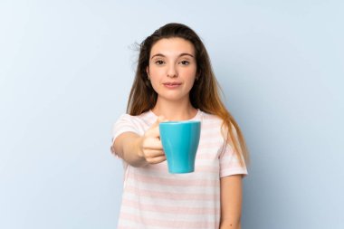 Genç esmer kız izole edilmiş arka planda bir fincan kahve tutuyor.