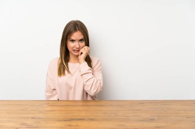 Masadaki genç kız gergin ve korkmuş.