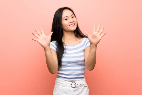 Soyutlanmış Pembe Arka Planda Genç Asyalı Kız Parmaklarıyla Ona Kadar — Stok fotoğraf