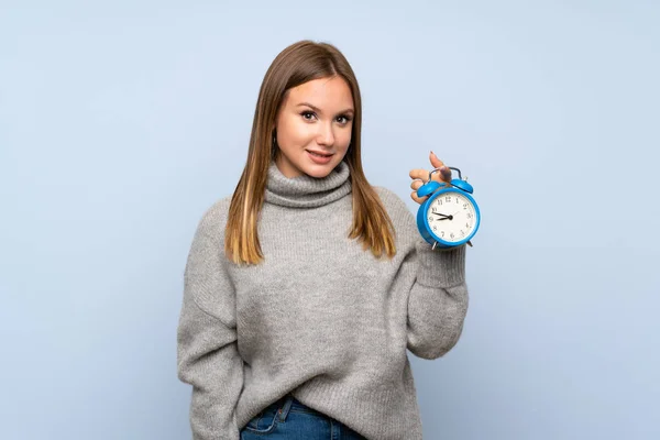 Tiener Meisje Met Trui Geïsoleerde Blauwe Achtergrond Holding Vintage Wekker — Stockfoto