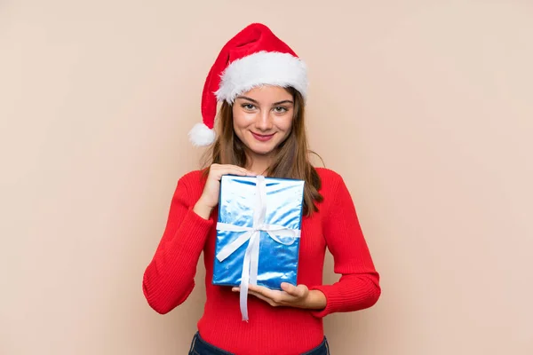 若いです女の子とともにクリスマス帽子保持ギフト上の隔離された背景 — ストック写真