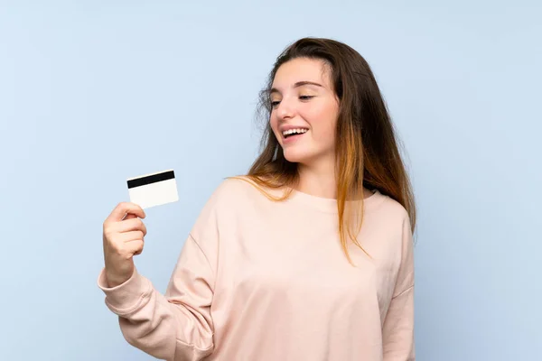 Jovem Morena Sobre Fundo Azul Isolado Segurando Cartão Crédito — Fotografia de Stock