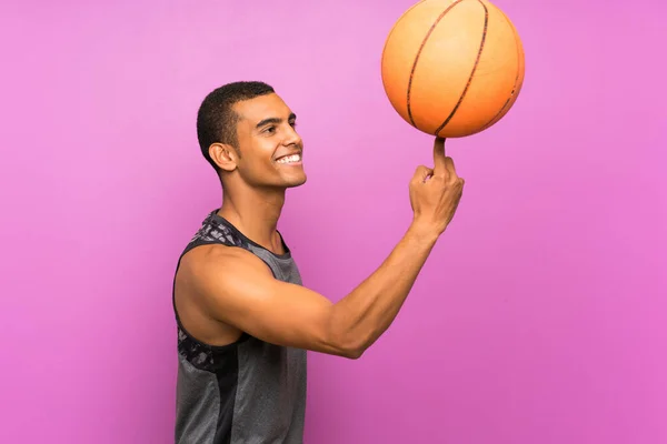 고립된 자주색 벽 위에서 농구 공을 가지고 있는 청소년 운동 선수 — 스톡 사진