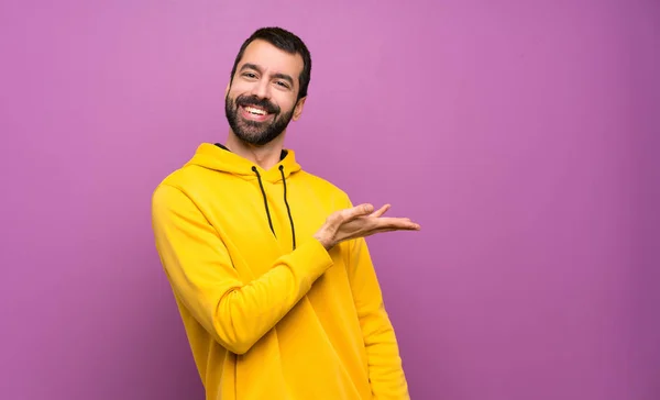 Bonito Homem Com Camisola Amarela Apresentando Uma Ideia Enquanto Olha — Fotografia de Stock