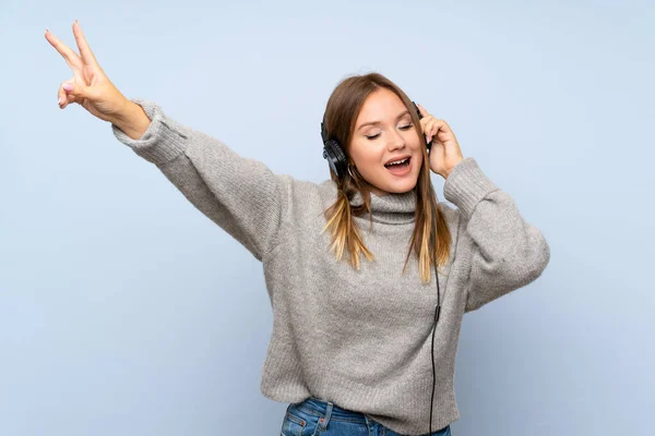 Teenager Girl Sweater Isolated Blue Background Listening Music Headphones — Stock Photo, Image