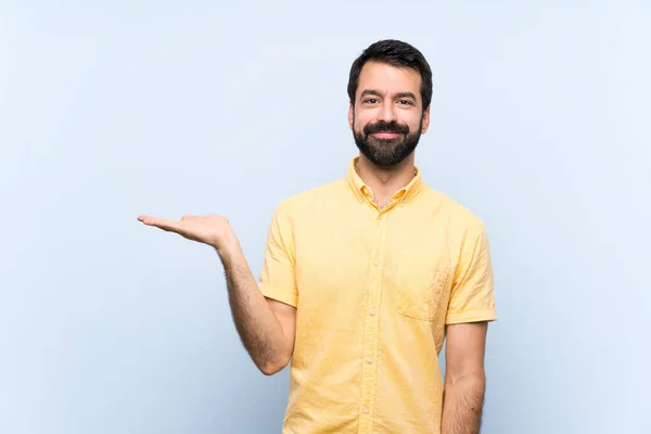 Young Man Beard Isolated Blue Background Holding Copyspace Imaginary Palm — Stock Photo, Image