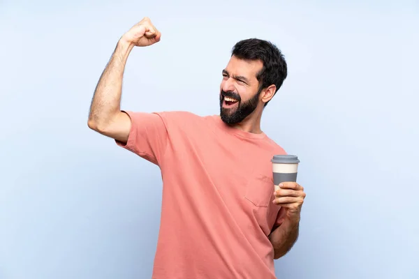 Jongeman Met Baard Houdt Een Afhaalkoffie Geïsoleerde Blauwe Achtergrond Vieren — Stockfoto