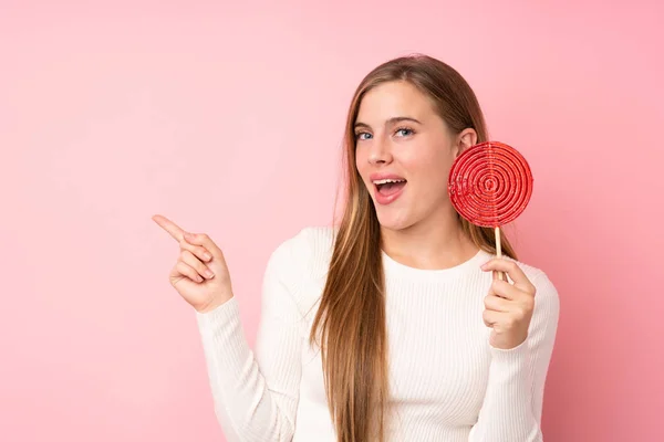 Teenager Ragazza Bionda Possesso Lecca Lecca Isolato Sfondo Rosa Sorpreso — Foto Stock