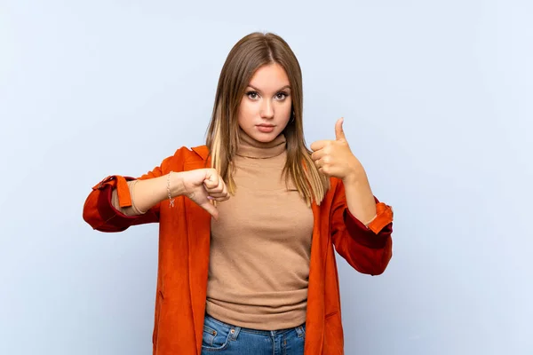 Ragazza Adolescente Con Cappotto Sfondo Blu Isolato Facendo Buon Cattivo — Foto Stock