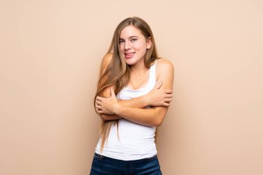 Genç sarışın kız izole edilmiş arka planda donuyor.