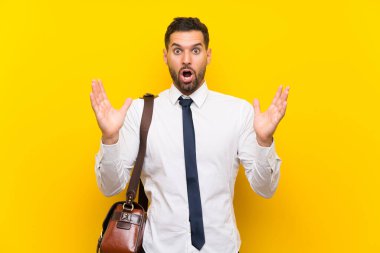 Sürpriz yüz ifadesi ile izole sarı arka plan üzerinde Yakışıklı işadamı