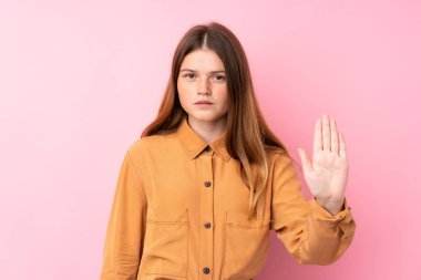 İzole edilmiş pembe arka planı olan Ukraynalı genç kız dur hareketi yapıyor.