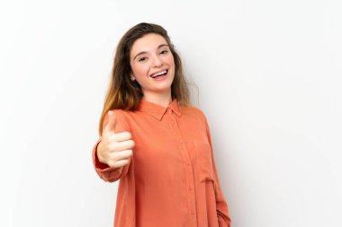 Genç esmer kız izole edilmiş beyaz arka planda. Başparmakları havada. Çünkü iyi bir şey oldu.