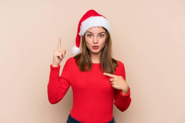 Yılbaşı şapkalı genç bir kız izole edilmiş bir geçmişi var ve yüzünde sürpriz bir ifade var.