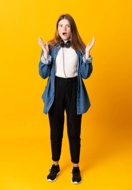 Öğrenci Ukraynalı genç kız, yalıtılmış sarı arka plan ve şaşırtıcı bir yüz ifadesi var.