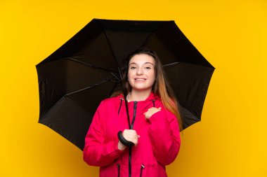 Sarı arka planda şemsiyesi olan esmer bir kız.