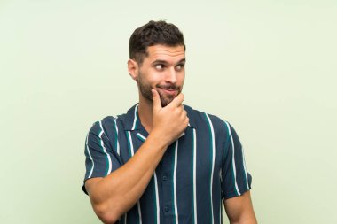 Izole arka plan üzerinde yakışıklı adam bir fikir düşünme