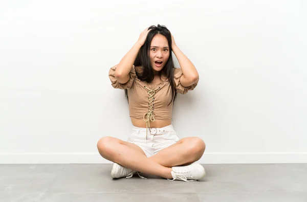 Adolescente Asiático Chica Sentado Suelo Con Sorpresa Facial Expresión —  Fotos de Stock