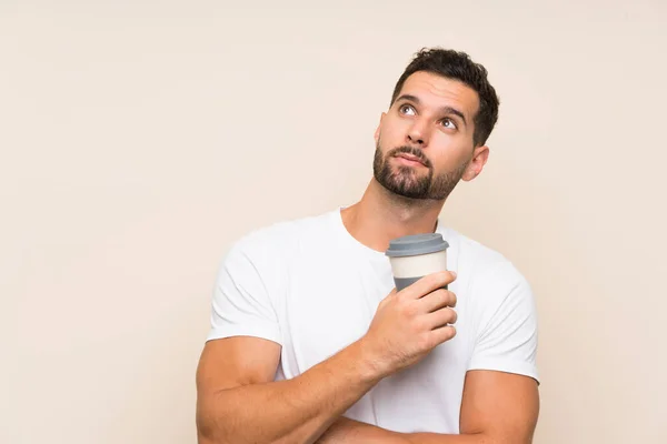 Jongeman Met Baard Houdt Een Take Away Koffie Geïsoleerde Blauwe — Stockfoto