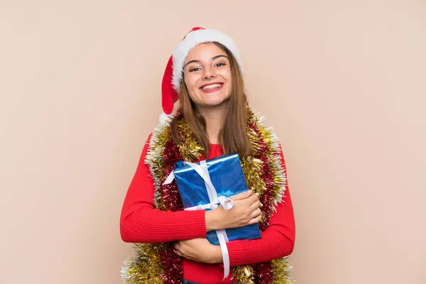 年轻姑娘戴着圣诞礼帽 背景孤僻 带着礼物 — 图库照片